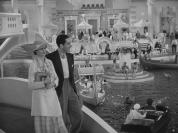 Movie still from “Top Hat” (1935), directed by Mark Sandrich – A man and a woman are walking in front of a fountain; Extreme Wide shot, High angle