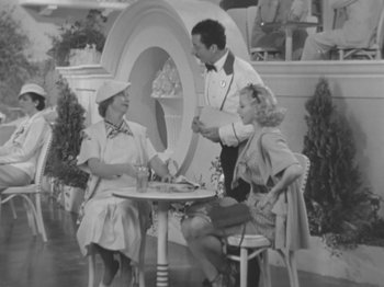 Movie still from “Top Hat” (1935), directed by Mark Sandrich – A man and two women sitting at a table; Medium shot, High angle