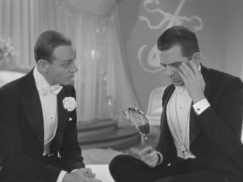 Movie still from “Top Hat” (1935), directed by Mark Sandrich – Two men in tuxedos sitting next to each other; Medium shot, High angle