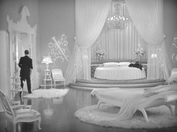 Movie still from “Top Hat” (1935), directed by Mark Sandrich – A black - and - white photo of a man and a woman in a bedroom; Wide shot, High angle