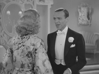 Movie still from “Top Hat” (1935), directed by Mark Sandrich – A man and a woman in formal wear talking to each other; Medium shot, Over the shoulder angle