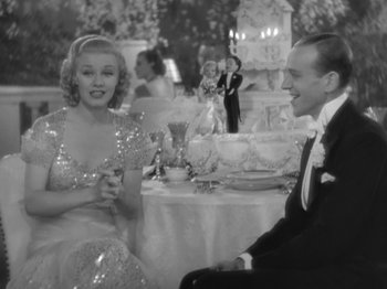 Movie still from “Top Hat” (1935), directed by Mark Sandrich – A man and a woman sitting at a dinner table; Medium shot, High angle