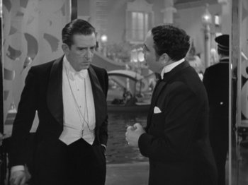 Movie still from “Top Hat” (1935), directed by Mark Sandrich – Two men in tuxedos talking to each other in front of a pond; Medium shot, Over the shoulder angle