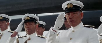 Movie still from “Tora! Tora! Tora!” (1970), directed by Kinji Fukasaku – A group of men in white suits and hats wave; Medium shot, Low angle