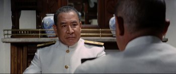 Movie still from “Tora! Tora! Tora!” (1970), directed by Kinji Fukasaku – A person wearing a uniform looking in the mirror; Close Up shot, Over the shoulder angle