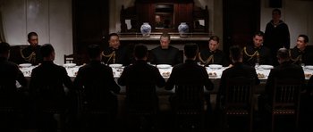 Movie still from “Tora! Tora! Tora!” (1970), directed by Kinji Fukasaku – A group of men sitting at a dinner table; Wide shot, High angle