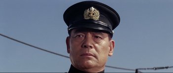 Movie still from “Tora! Tora! Tora!” (1970), directed by Kinji Fukasaku – A person wearing a hat; Close Up shot, Low angle