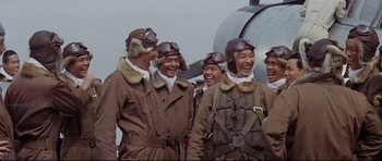Movie still from “Tora! Tora! Tora!” (1970), directed by Kinji Fukasaku – A group of men in brown coats standing next to each other; Medium shot, Low angle