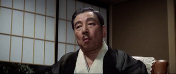 Movie still from “Tora! Tora! Tora!” (1970), directed by Kinji Fukasaku – An older man wearing a black robe and a white shirt; Close Up shot, Low angle