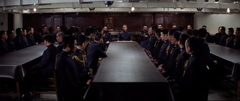 Movie still from “Tora! Tora! Tora!” (1970), directed by Kinji Fukasaku – A group of men sitting around a table in a room; Wide shot, High angle