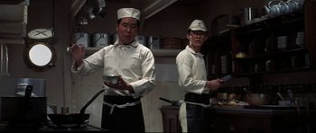 Movie still from “Tora! Tora! Tora!” (1970), directed by Kinji Fukasaku – Two men in white shirts and white hats in a kitchen; Medium shot, Low angle