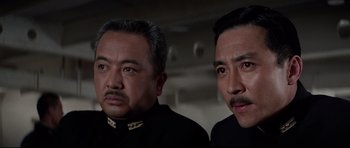Movie still from “Tora! Tora! Tora!” (1970), directed by Kinji Fukasaku – Two men in black shirts and one has a mustache; Close Up shot, Low angle