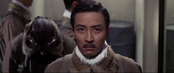 Movie still from “Tora! Tora! Tora!” (1970), directed by Kinji Fukasaku – A person wearing a suit and tie; Close Up shot, Low angle