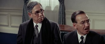 Movie still from “Tora! Tora! Tora!” (1970), directed by Kinji Fukasaku – A man in a suit and tie sitting next to a man in a tie; Close Up shot, Over the shoulder angle