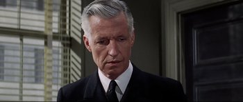 Movie still from “Tora! Tora! Tora!” (1970), directed by Kinji Fukasaku – An older man wearing a suit and tie; Close Up shot, High angle