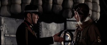 Movie still from “Tora! Tora! Tora!” (1970), directed by Kinji Fukasaku – A man and a woman in military uniforms talking to each other; Medium shot, Over the shoulder angle