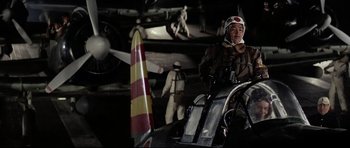 Movie still from “Tora! Tora! Tora!” (1970), directed by Kinji Fukasaku – A man standing next to an airplane in a hangar; Medium shot, Low angle