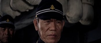 Movie still from “Tora! Tora! Tora!” (1970), directed by Kinji Fukasaku – A man wearing a hat and a uniform; Close Up shot, Low angle