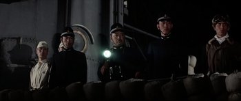 Movie still from “Tora! Tora! Tora!” (1970), directed by Kinji Fukasaku – A group of men standing next to each other holding a flashlight; Medium shot, Low angle
