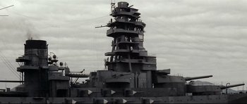 Movie still from “Tora! Tora! Tora!” (1970), directed by Kinji Fukasaku – A black and white photo of a large battleship; Extreme Wide shot, Low angle