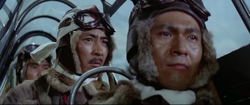 Movie still from “Tora! Tora! Tora!” (1970), directed by Kinji Fukasaku – Two men are wearing hats and goggles while sitting in an airplane cockpit; Close Up shot, Low angle