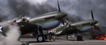 Movie still from “Tora! Tora! Tora!” (1970), directed by Kinji Fukasaku – Two men working on an airplane on a runway; Wide shot, Low angle