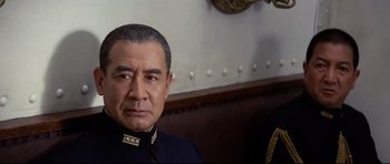 Movie still from “Tora! Tora! Tora!” (1970), directed by Kinji Fukasaku – A person wearing a suit and tie; Close Up shot, Over the shoulder angle