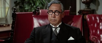 Movie still from “Tora! Tora! Tora!” (1970), directed by Kinji Fukasaku – An older man wearing a suit and tie; Close Up shot, Over the shoulder angle
