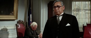 Movie still from “Tora! Tora! Tora!” (1970), directed by Kinji Fukasaku – A man in a suit and tie next to another man in a suit and tie; Close Up shot, Low angle