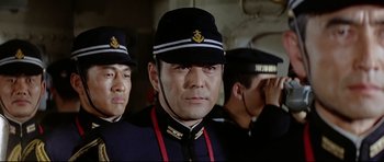 Movie still from “Tora! Tora! Tora!” (1970), directed by Kinji Fukasaku – A group of men standing next to each other wearing uniforms; Close Up shot, Low angle