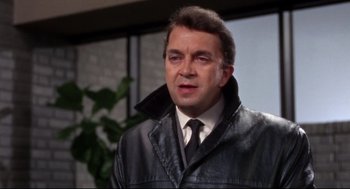 Movie still from “Torn Curtain” (1966), directed by Alfred Hitchcock – A person wearing a suit and tie; Close Up shot, High angle