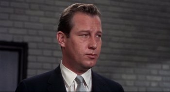 Movie still from “Torn Curtain” (1966), directed by Alfred Hitchcock – A person wearing a suit and tie; Close Up shot, Low angle