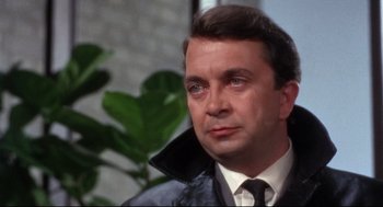 Movie still from “Torn Curtain” (1966), directed by Alfred Hitchcock – A person wearing a suit and tie; Close Up shot, High angle