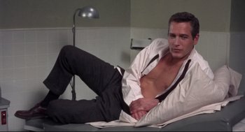 Movie still from “Torn Curtain” (1966), directed by Alfred Hitchcock – A man laying on the ground with his shirt open; Medium shot, High angle