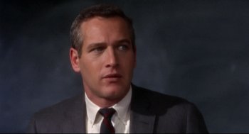 Movie still from “Torn Curtain” (1966), directed by Alfred Hitchcock – A man in a gray suit and a red tie; Close Up shot, Over the shoulder angle