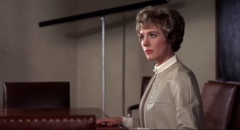 Movie still from “Torn Curtain” (1966), directed by Alfred Hitchcock – A woman standing in front of a table; Medium shot, Low angle