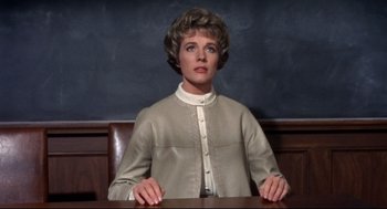 Movie still from “Torn Curtain” (1966), directed by Alfred Hitchcock – A woman sitting at a table in front of a chalkboard; Medium shot, Low angle
