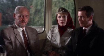 Movie still from “Torn Curtain” (1966), directed by Alfred Hitchcock – A group of people sitting in a train car; Medium shot, Over the shoulder angle