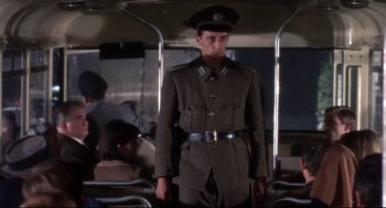 Movie still from “Torn Curtain” (1966), directed by Alfred Hitchcock – A man in a uniform standing on a bus; Medium shot, Low angle