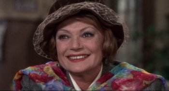 Movie still from “Torn Curtain” (1966), directed by Alfred Hitchcock – An older woman wearing a hat and a colorful jacket; Close Up shot, High angle