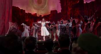 Movie still from “Torn Curtain” (1966), directed by Alfred Hitchcock – A group of people on a stage performing a dance; Wide shot, Low angle