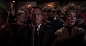 Movie still from “Torn Curtain” (1966), directed by Alfred Hitchcock – A man in a suit and tie in a crowd of people; Medium shot, Low angle