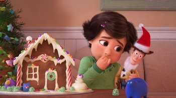 Movie still from “Toy Story That Time Forgot” (2014), directed by Steve Purcell – A person sitting in front of a gingerbread house; Close Up shot, Over the shoulder angle