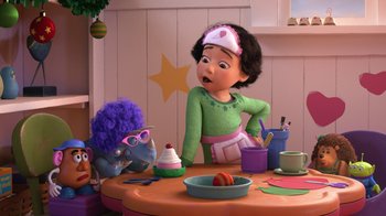 Movie still from “Toy Story That Time Forgot” (2014), directed by Steve Purcell – A person sitting at a table with a stuffed animal; Medium shot, Over the shoulder angle