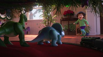 Movie still from “Toy Story That Time Forgot” (2014), directed by Steve Purcell – A toy dinosaur is standing in the middle of a living room; Wide shot, High angle