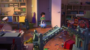 Movie still from “Toy Story That Time Forgot” (2014), directed by Steve Purcell – A child is playing with a toy train in a messy room; Wide shot, High angle