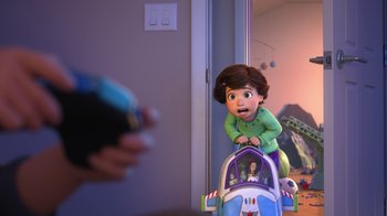 Movie still from “Toy Story That Time Forgot” (2014), directed by Steve Purcell – A person is playing with a toy in a room with a mirror; Medium shot, Over the shoulder angle