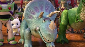 Movie still from “Toy Story That Time Forgot” (2014), directed by Steve Purcell – A blue triceratops toy sitting on top of a wooden table; Close Up shot, High angle