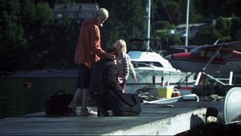 Movie still from “Trapped” (2002), directed by Luis Mandoki – A woman and a little girl standing on a dock with a suitcase; Wide shot, High angle