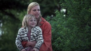 Movie still from “Trapped” (2002), directed by Luis Mandoki – A woman and a child are posing for a picture; Close Up shot, Low angle
